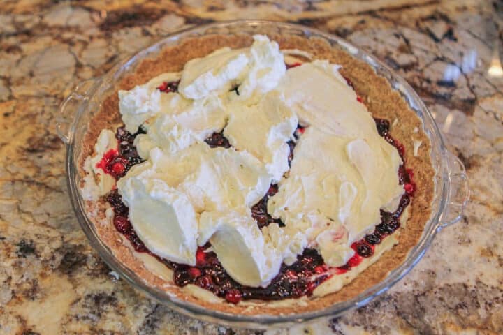 layered berry cheesecake with whipped cream