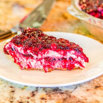 a slice of berry cheesecake on a white plate