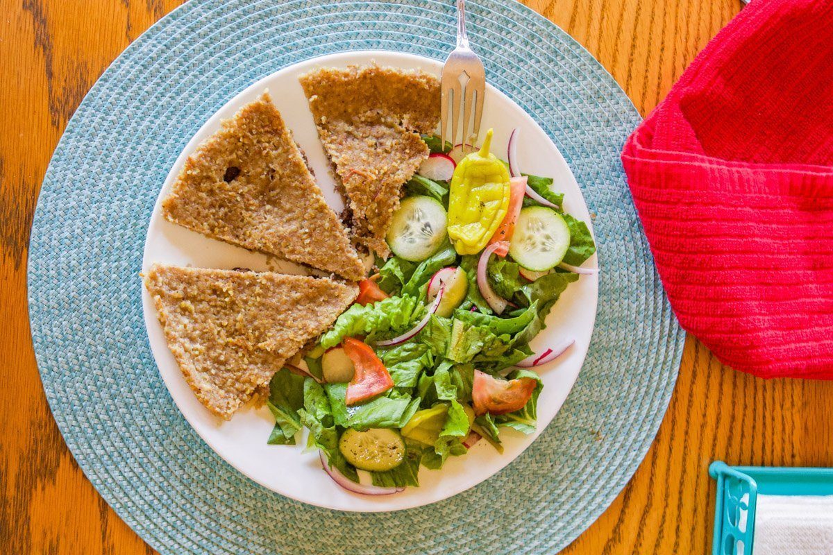 kubba mosul on a white plate with salad