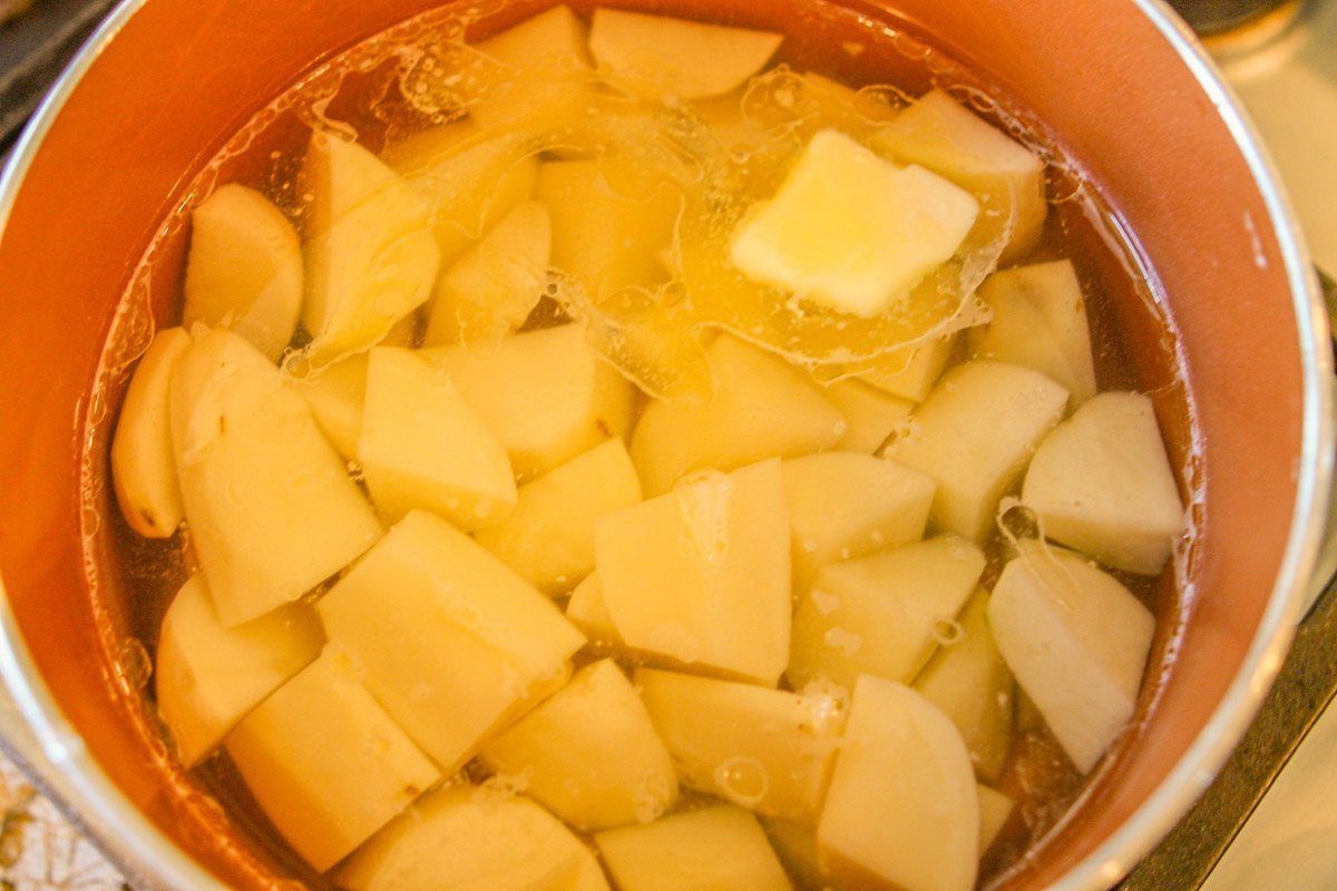 chopped potatoes and a tab of butter in a saucepan