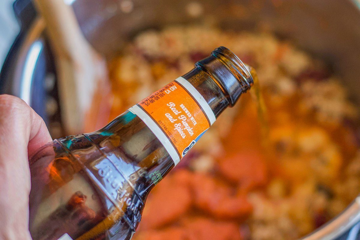 pumpkin beer being poured into chili