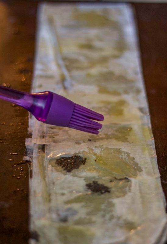 fillo dough strips being brushed with oil