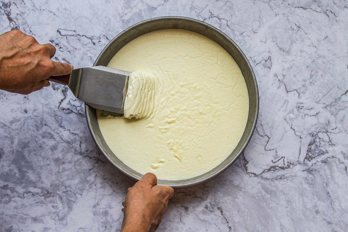 scooping out clotted cream from a pan