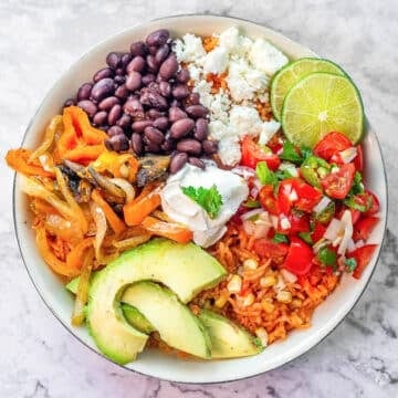 vegetarian Mexican rice bowl full of veggies, cheese, beans, etc.