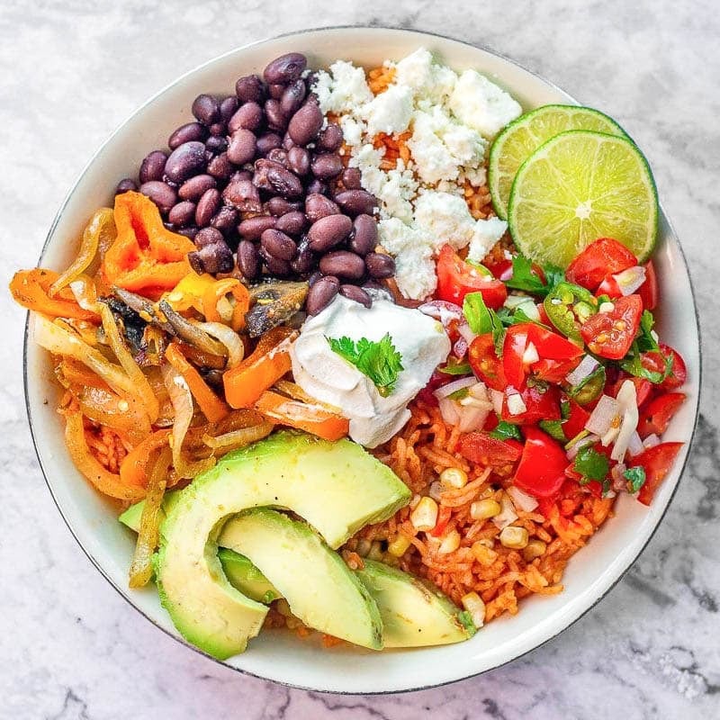 vegetarian Mexican rice bowl full of veggies, cheese, beans, etc.