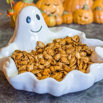 seasoned pumpkin seeds in a white ghost bowl