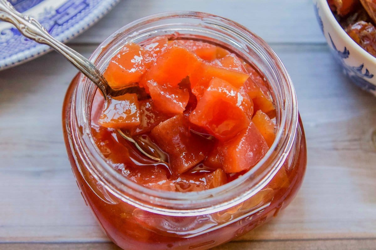 quince preserves in a jar with a spoon in the jar