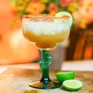 tamarind margarita with sliced lime wedges.