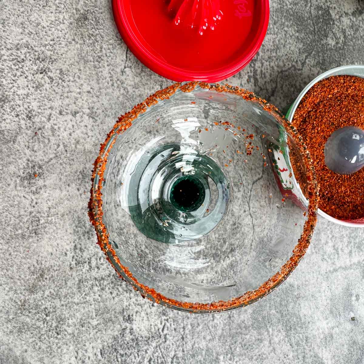 tajin rimmed margarita glass with more tajin in the background.