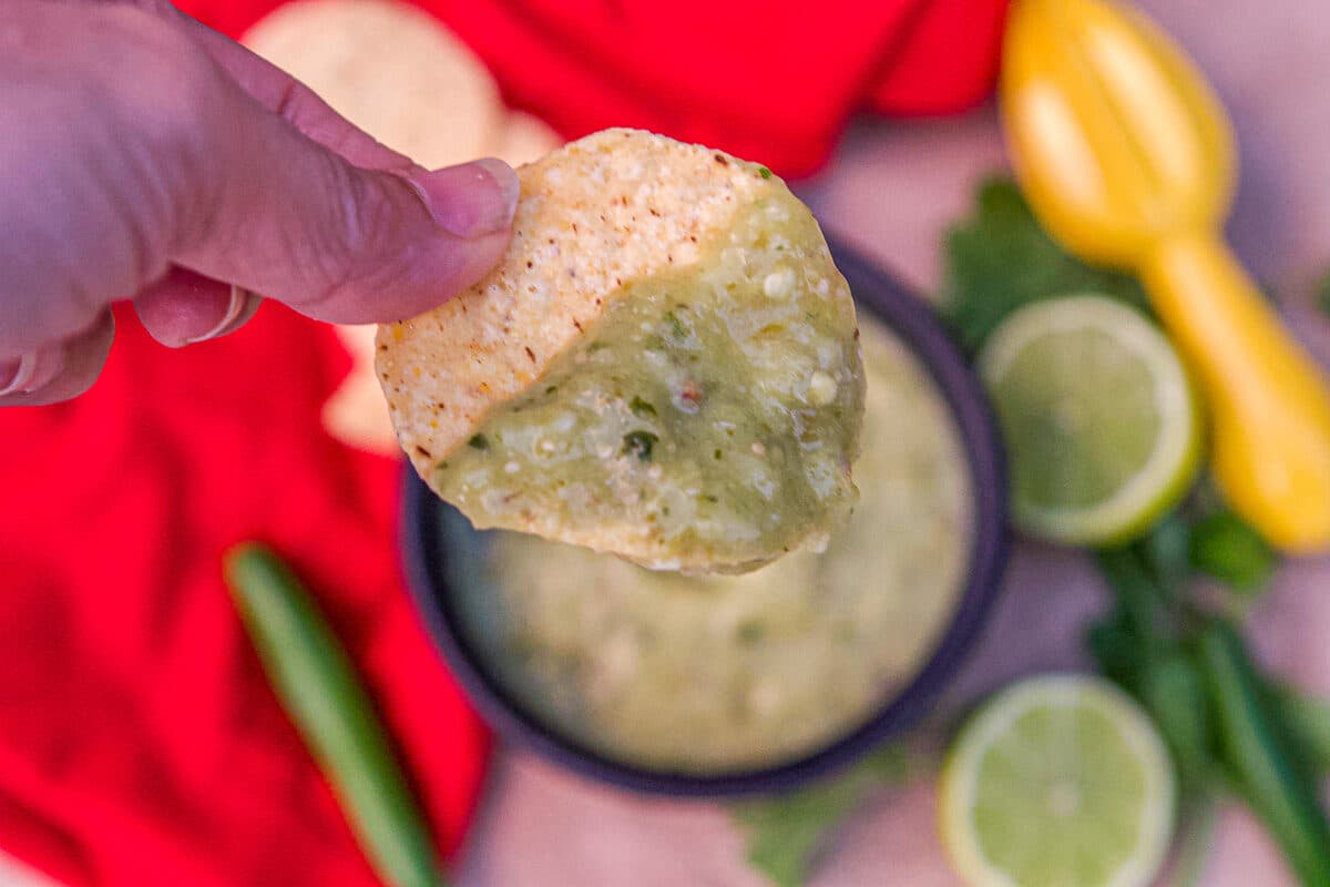 chip being dipped into Tomatillo Green Chili Salsa