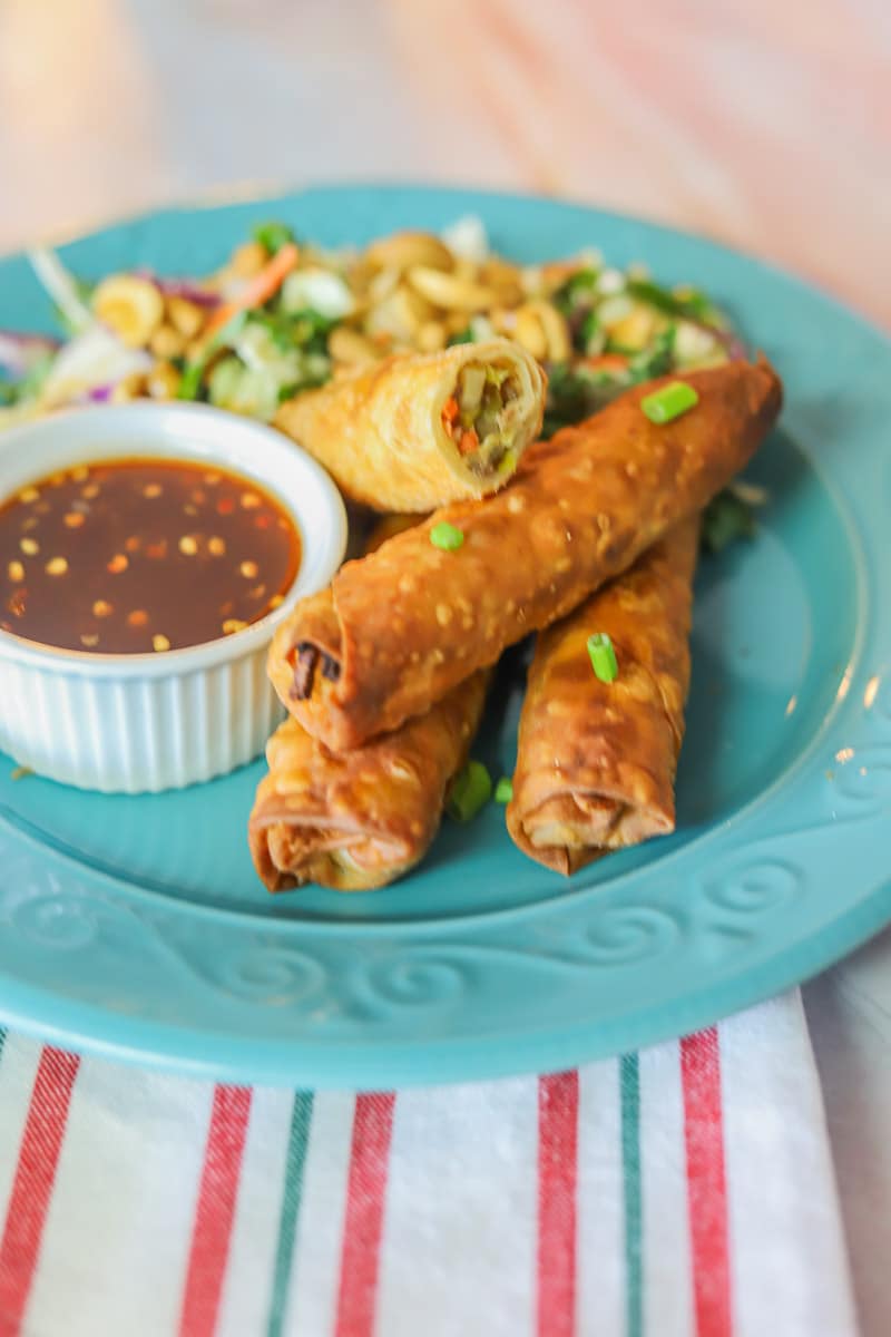 lumpia and sauce and salad on a blue plate