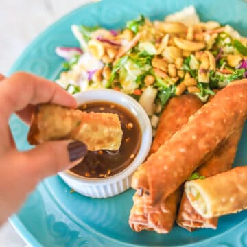 lumpia being dipped in sauce