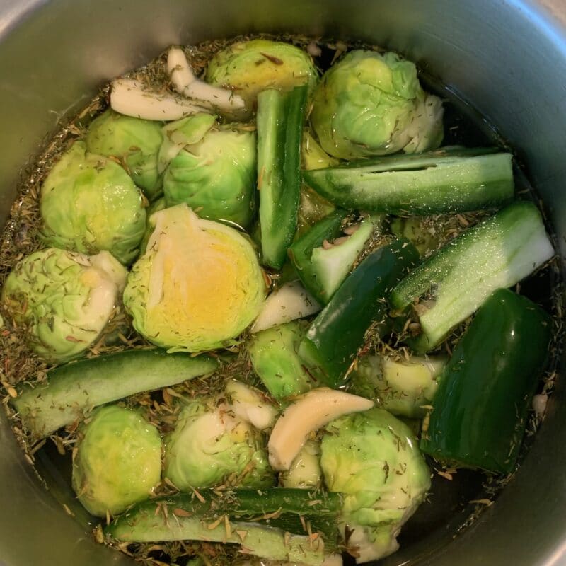sliced Brussel Sprouts with garlic and pepper in a bowl with picking spices