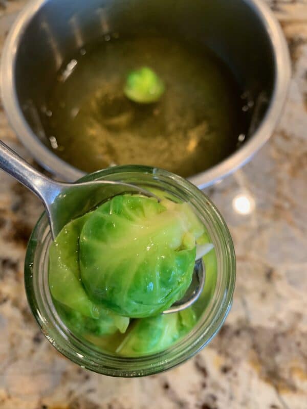 adding Brussel Sprouts in a jar to pickle