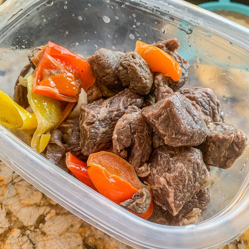 cubed meat and peppers in a plastic Tupperware