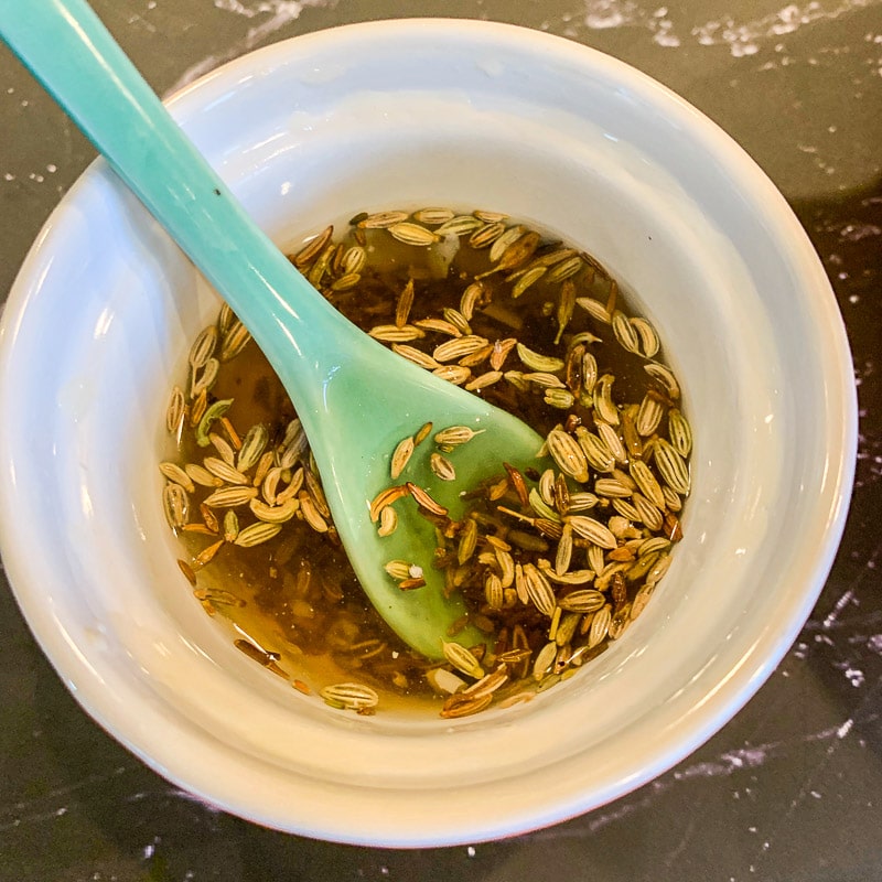seeds and water in a small bowl with green spoon