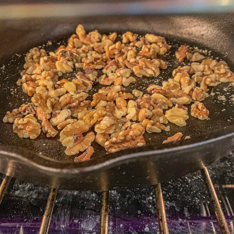 toasting walnuts in a pan in the oven