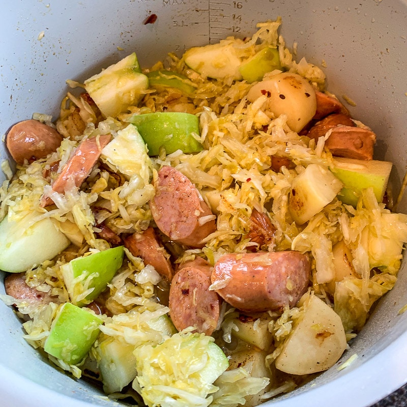 chopped apple and sauerkraut in a bowl with sausage