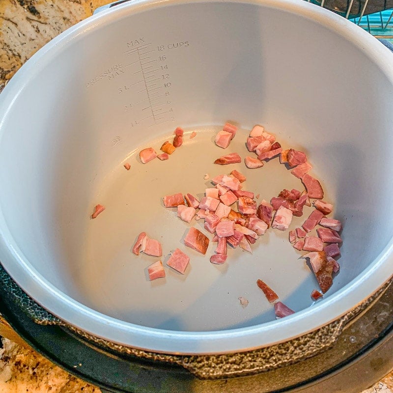 chopped bacon frying in a pan