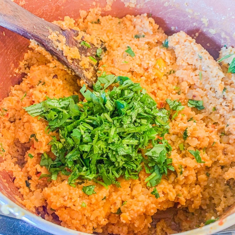 red lentil kibbeh mixture with diced parsley on top