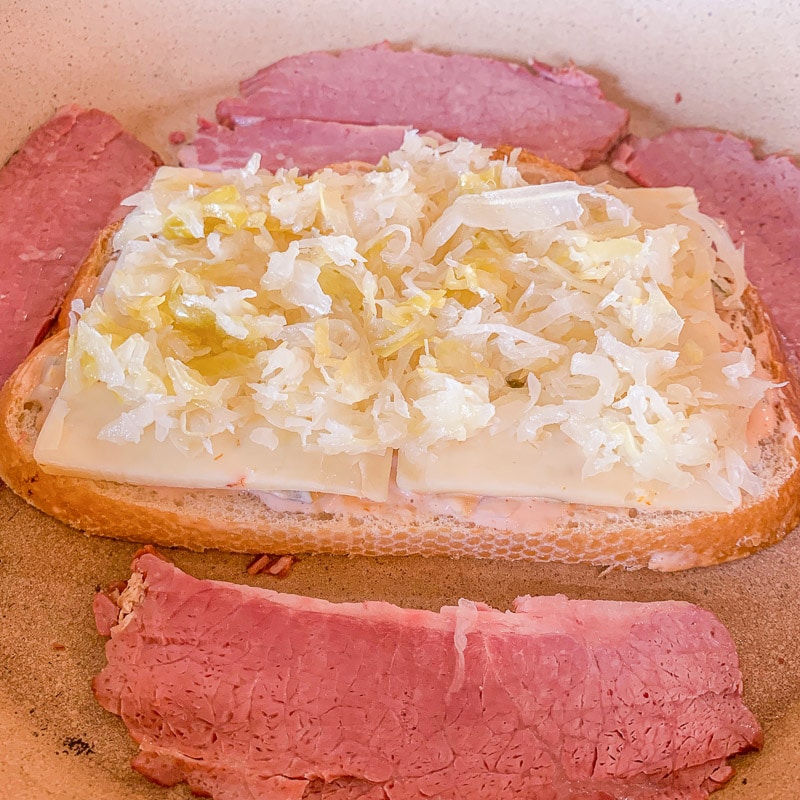 bread with cheese and sauerkraut  and corned beef in a pan