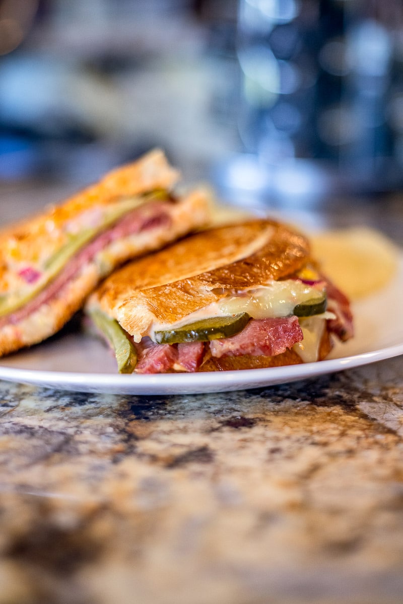 reuben sandwich recipe on a white plate on the counter