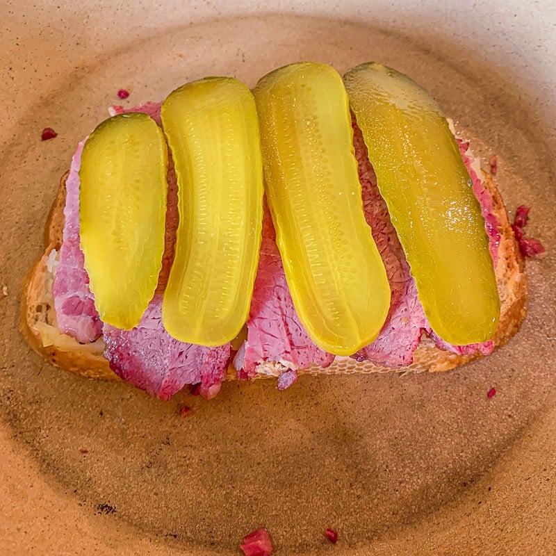 reuben sandwich with pickles in a pan