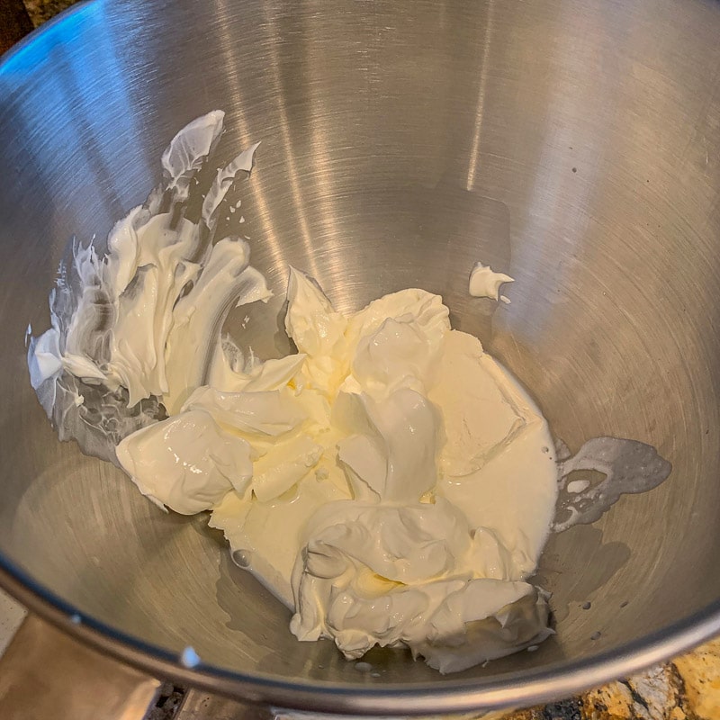 cream cheese, sour cream in a silver mixing bowl
