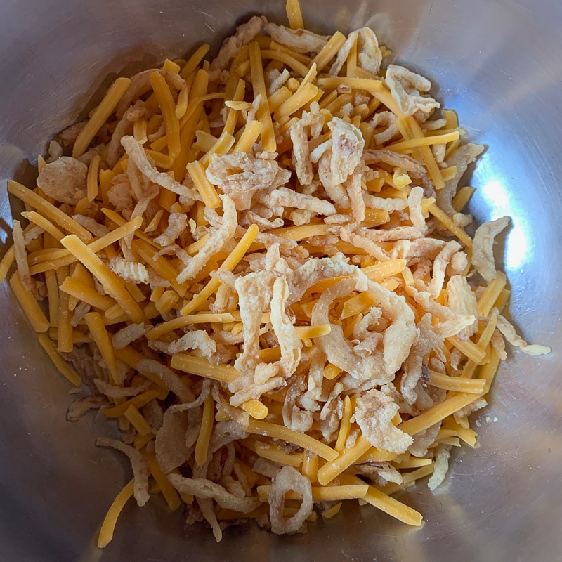 fried onions and shredded cheese in a bowl