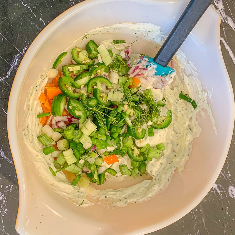 cream cheese and veggies in a white bowl