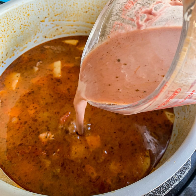 slurry being poured into venison stew