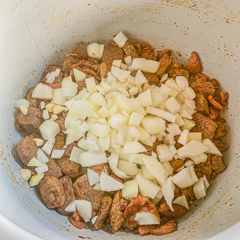 meat and onions in pressure cooker