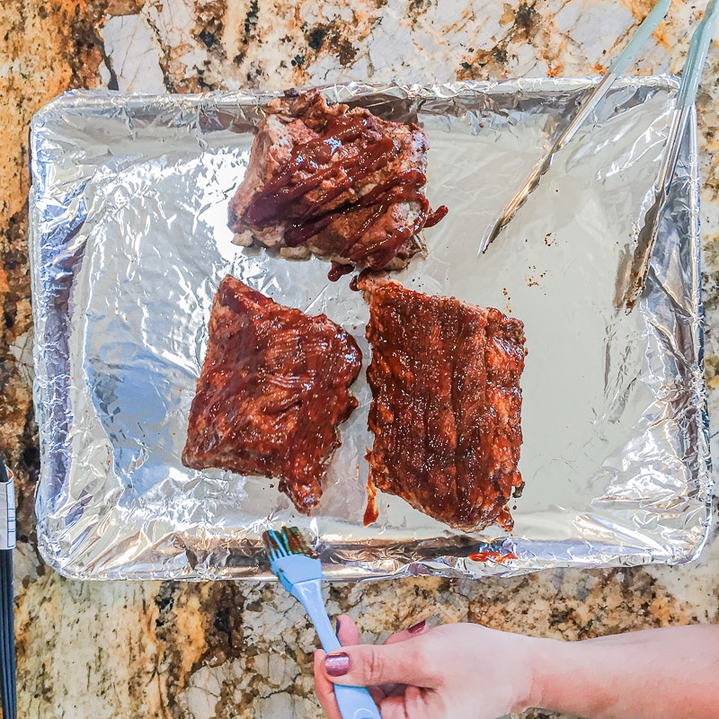 brushing Instant Pot Baby Back Ribs with sauce