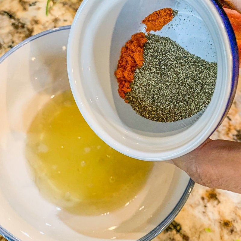 adding spices to olive oil bowl