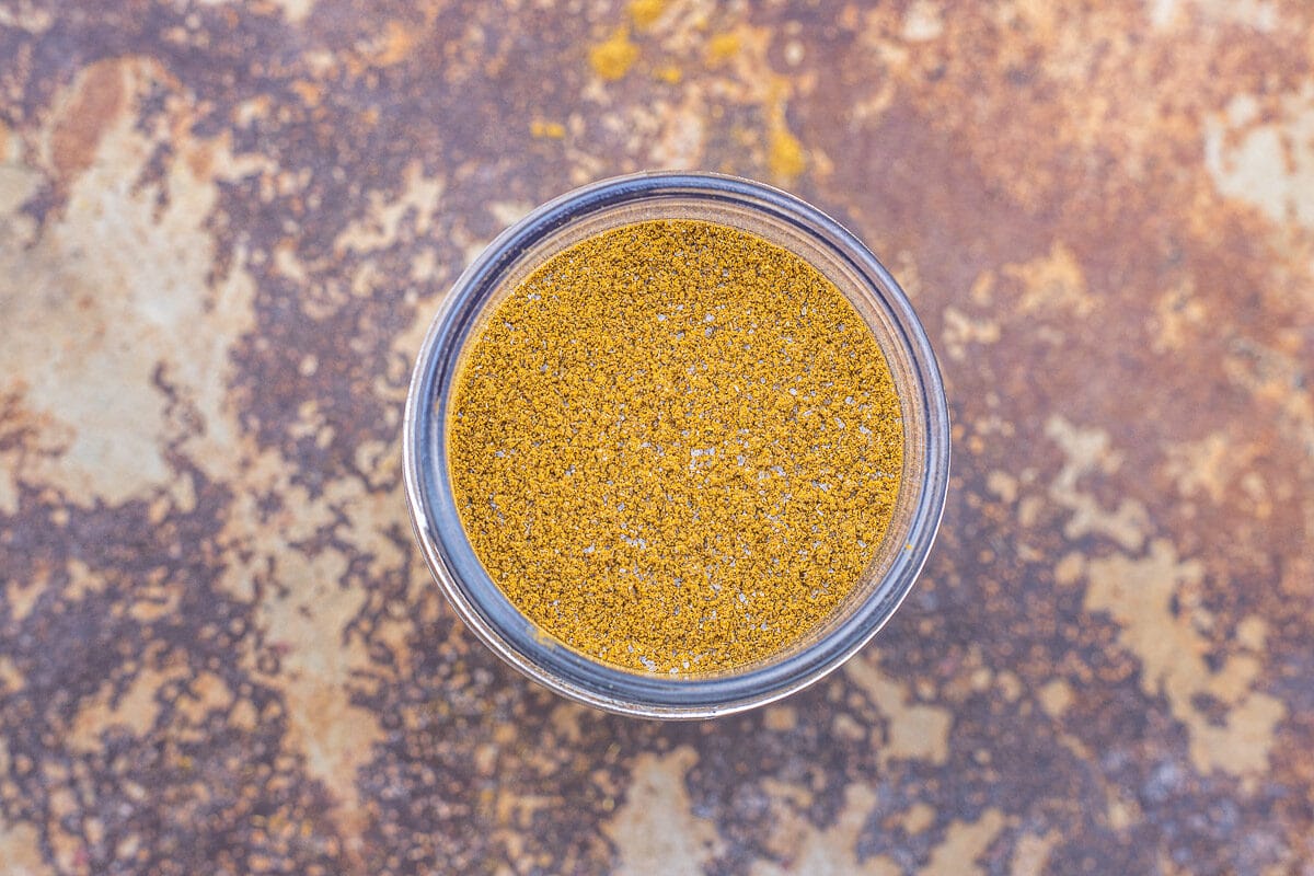biryani spice blend in a jar on a brown tile background