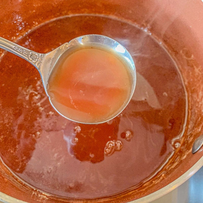 spooning syrup in a pot full of date syrup