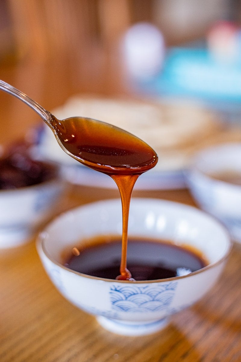 date syrup being drizzled into a small bowl