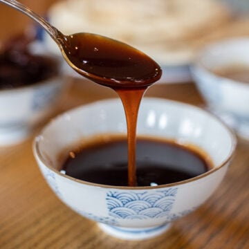 spoonful of date syrup being drizzled into a small bowl