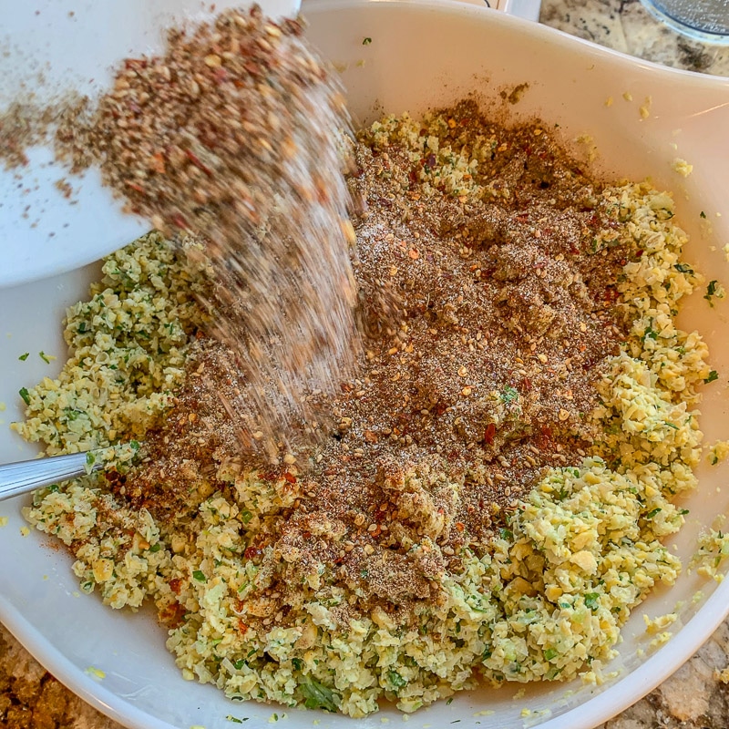 adding seasoning to falafel recipe