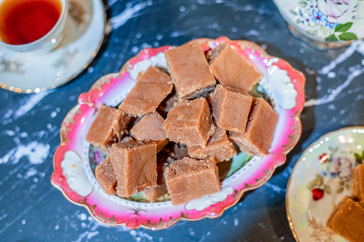 halwa in a bowl with tea next to it.