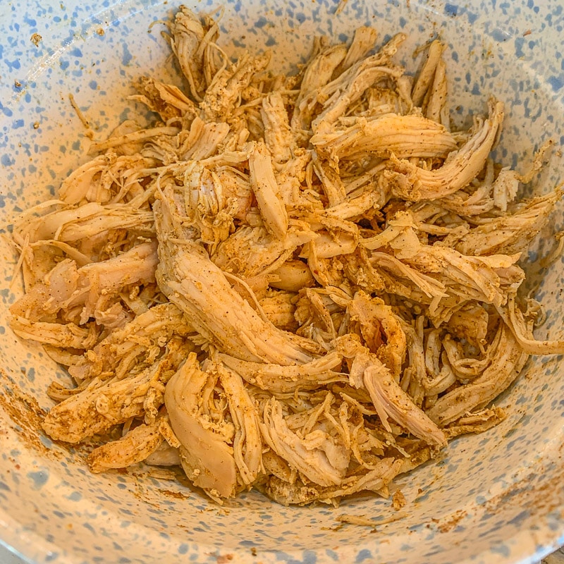 seasoned shredded chicken in a speckled bowl