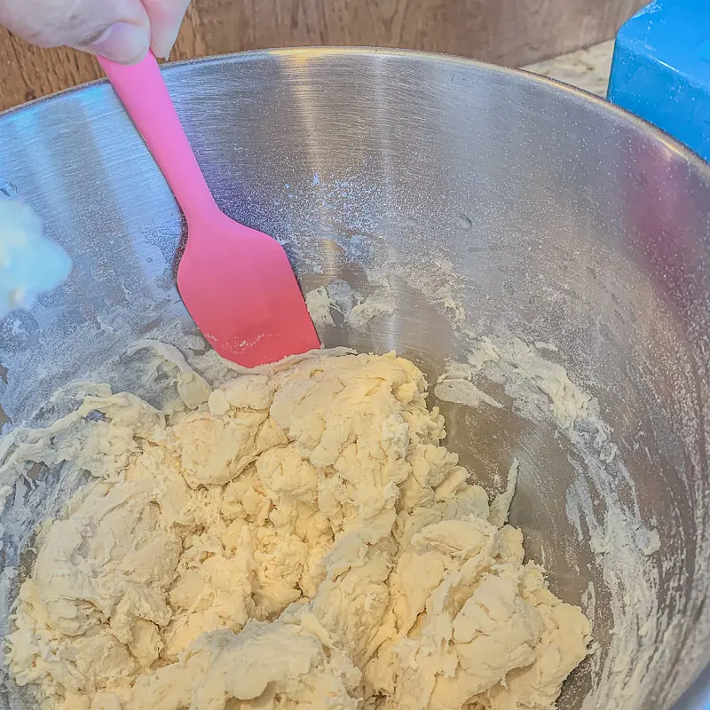 scratching des côtés du bol de pâte. à l'aide d'une spatule rose