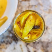 pickled mango in a jar with sliced mangos on the side