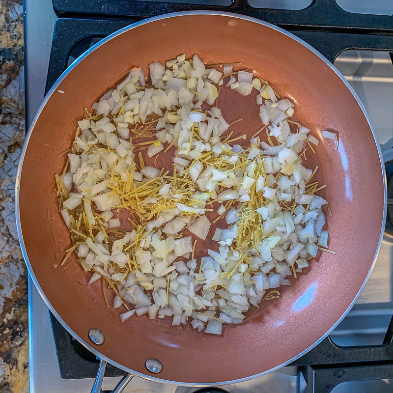 brown pan with diced onion and noodles