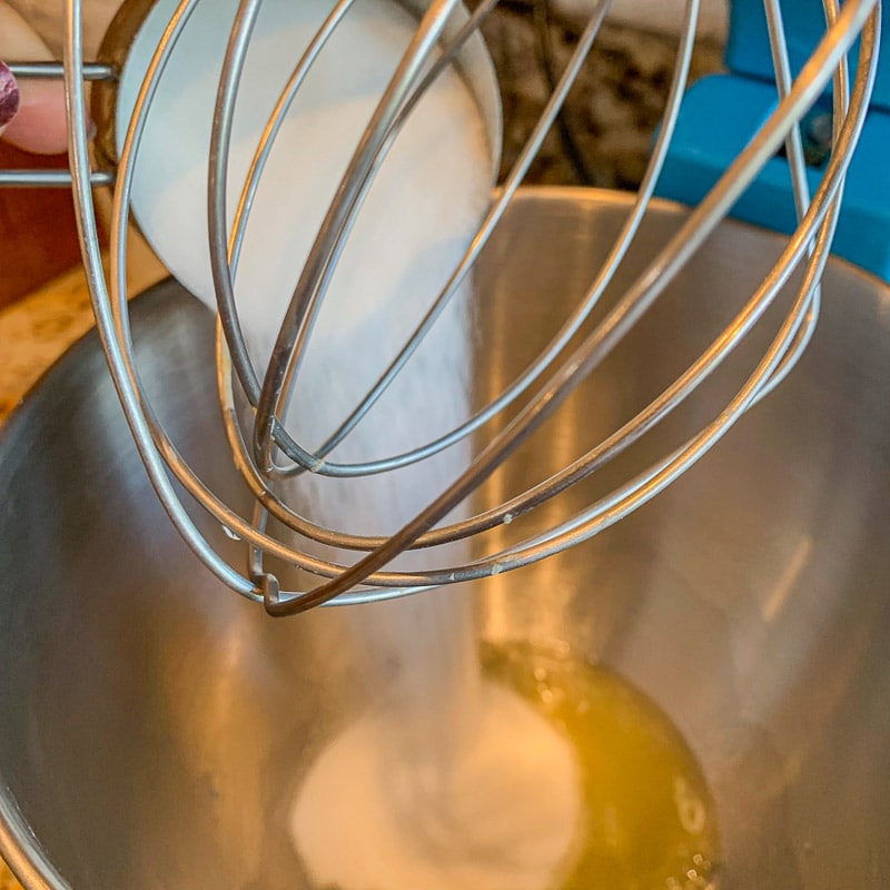 sugar being added to a mixing bowl