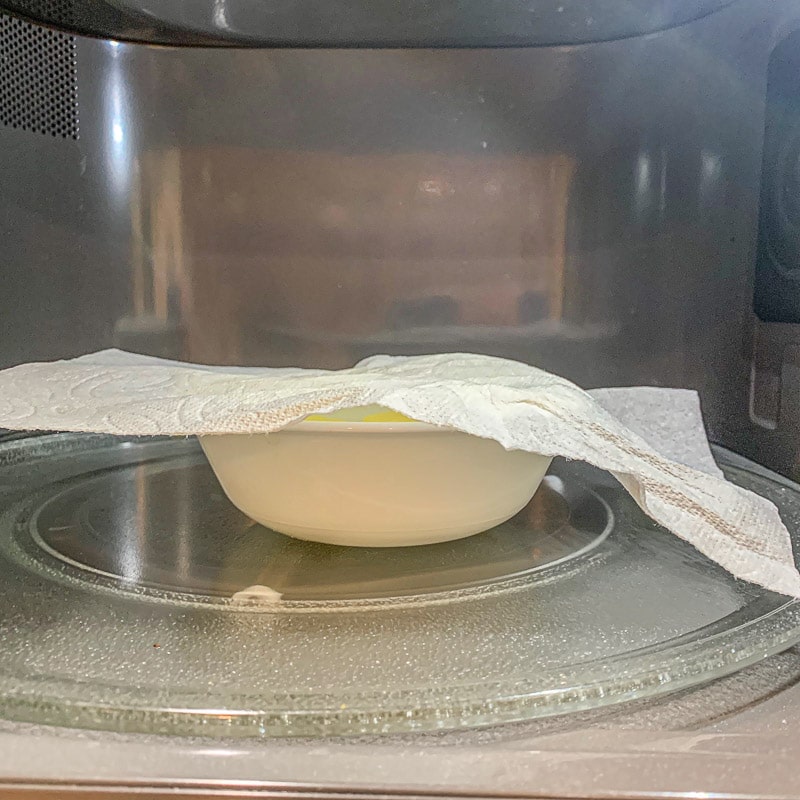 white bowl covered with a napkin in the microwave