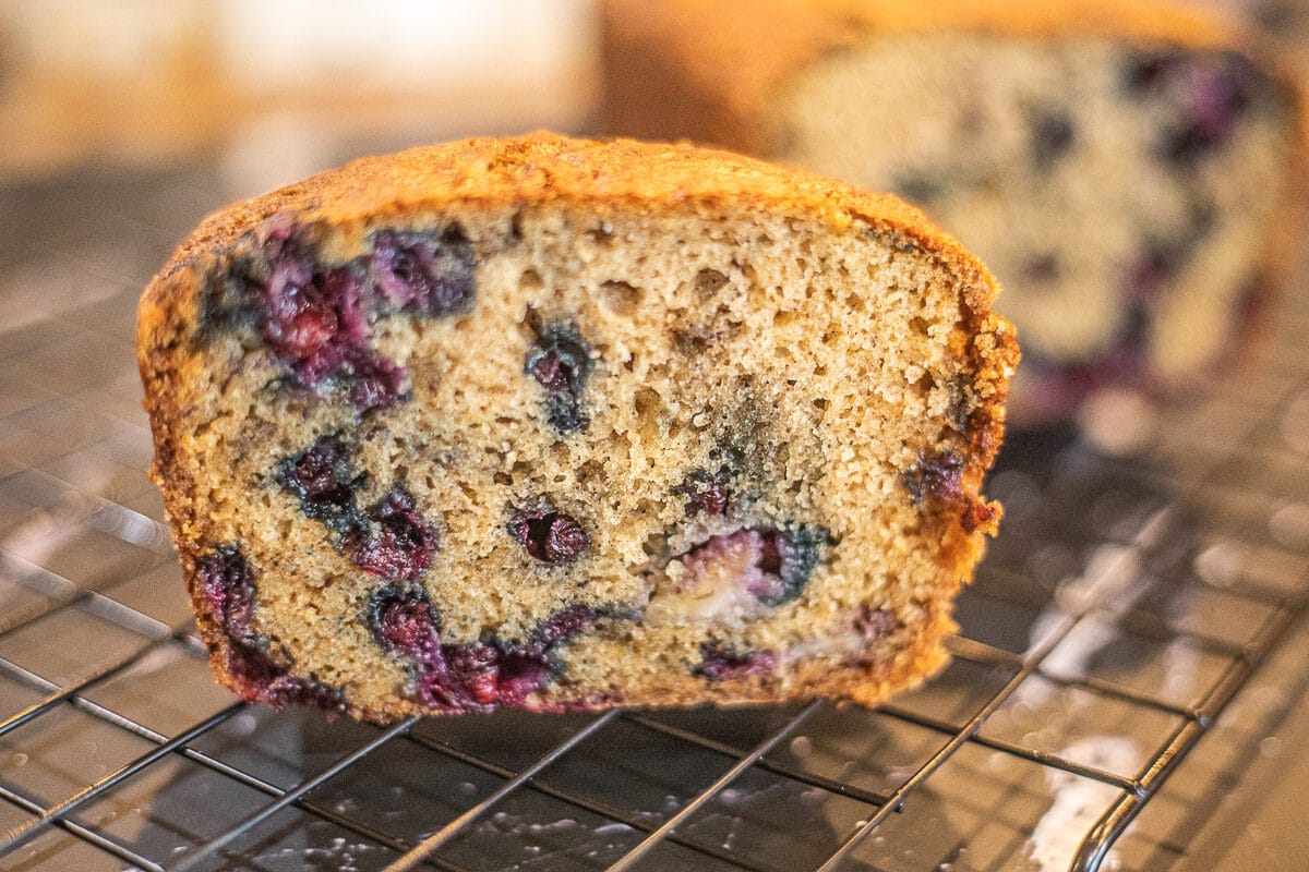 sliced blueberry banana bread on a wire rack