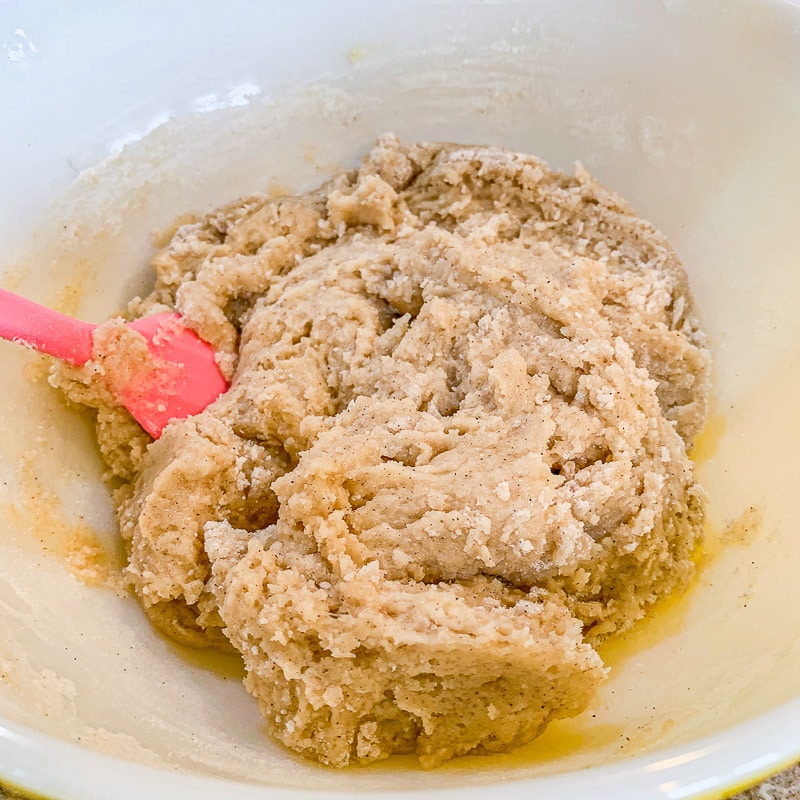 mixing batter for classic banana bread with a pink spatula
