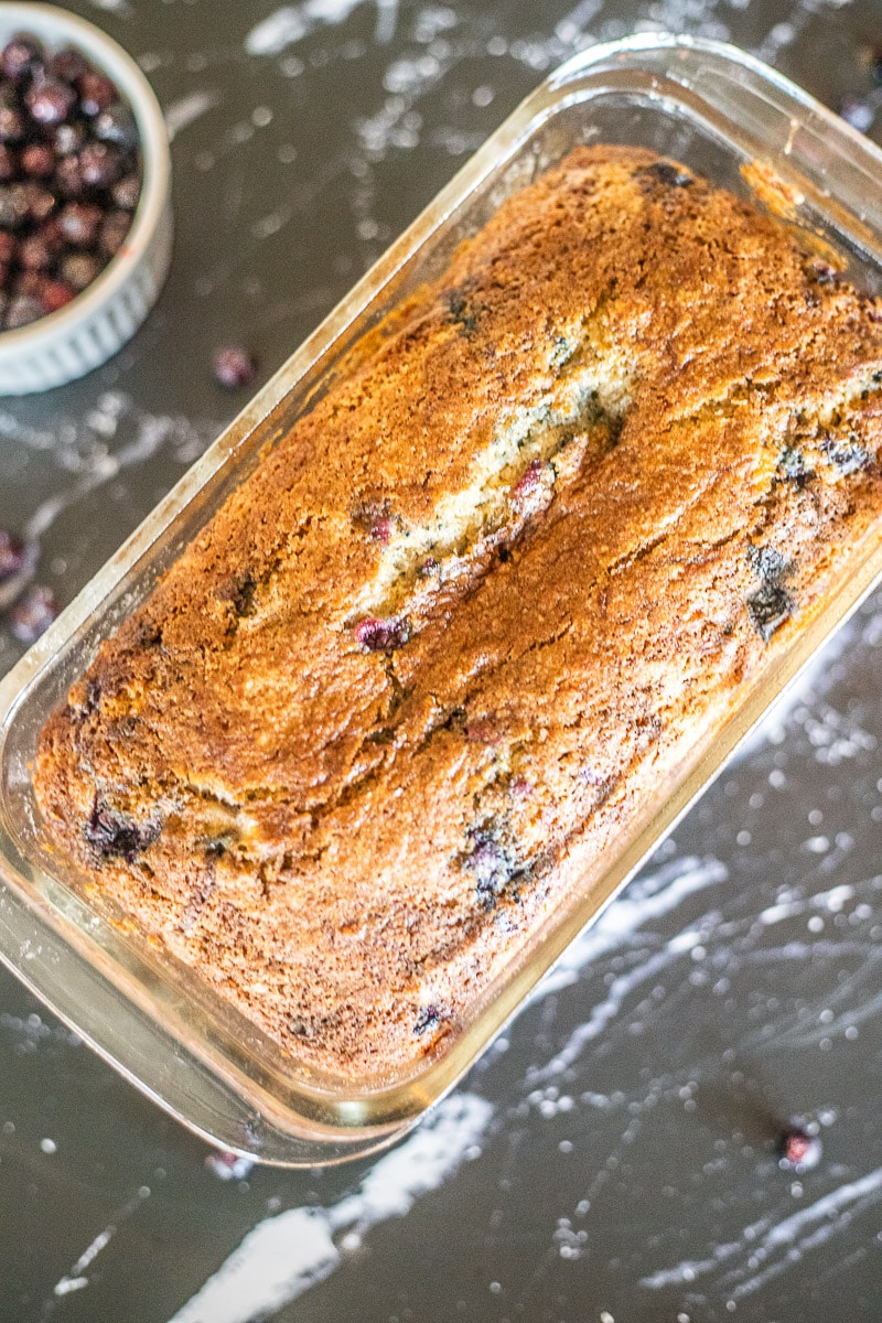 classic banana bread recipe with huckleberries on a marbled counter