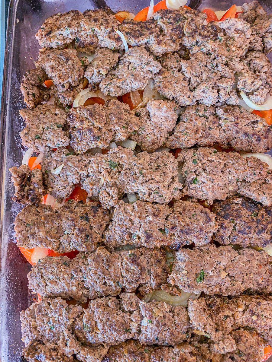 layered casserole ingredients topped with kabob on top